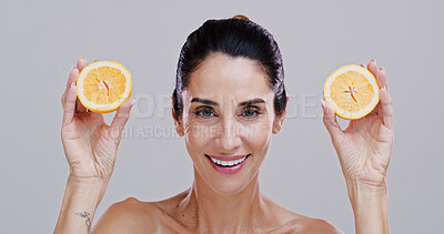 Buy stock photo Portrait, orange and woman with skincare, wellness and dermatology on gray studio background. Mature person, organic cosmetics or model with confidence, citrus and natural detox with beauty or facial