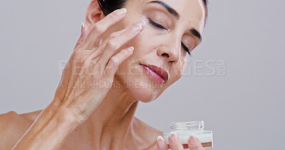 Buy stock photo Skincare, mature woman and face cream in studio for anti aging treatment, wrinkle reduction and skin hydration. Space, person and beauty product application for self care wellness on white background