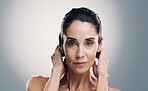 Beauty, portrait and serious with woman in studio for antiaging treatment or wellness routine. Cosmetics, dermatology and skincare with mature model on gray background for facial transformation