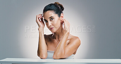 Buy stock photo Serious, cosmetics and mature woman with skincare, portrait and treatment for shine of skin and studio. Gray background, mockup space and glow with dermatology, confident and wellness for person