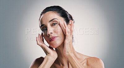 Buy stock photo Natural skincare, portrait and woman with glow, touch and results of collagen treatment for anti aging. Mature model, confident face and cosmetics, dermatology and beauty on gray studio background
