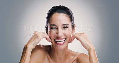 Buy stock photo Natural skincare, portrait and woman laugh with glow, touch and collagen treatment for anti aging. Mature model, happy face and cosmetics, dermatology and shine for beauty on gray studio background