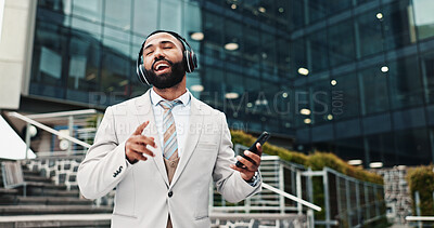 Buy stock photo Singing, man and phone with headphones in city for music playlist, streaming audio and work break outdoor. Business, professional and dancing to track for sound subscription or listening to radio app