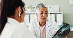 Consulting, healthcare or x ray with doctor and patient in office of hospital for diagnosis. Appointment, feedback or radiology with mature medical professional and woman in clinic for treatment