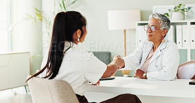 Buy stock photo Appointment, healthcare or shaking hands with doctor and patient in office of hospital for consulting. Conversation, handshake or medical with mature medicine professional and woman meeting in clinic