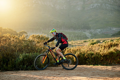 Buy stock photo Man, cyclist and nature with mountain bike for extreme sport, fitness or outdoor exercise. Active, male person or riding in wilderness with bicycle or helmet for cycling or adrenaline on dirt road