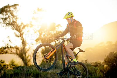 Buy stock photo Bike, off road and wheelie with man in mountains for outdoor adrenaline, adventure or training. Balance, exercise and fitness hobby with cyclist in nature for challenge, competition or performance