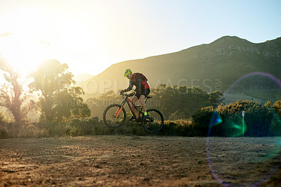 Buy stock photo Man, mountain bike or cycling with dirt road for fitness, extreme sport or cardio workout in nature. Active, cyclist or riding with bicycle, sunset or backpack for adrenaline rush or outdoor exercise