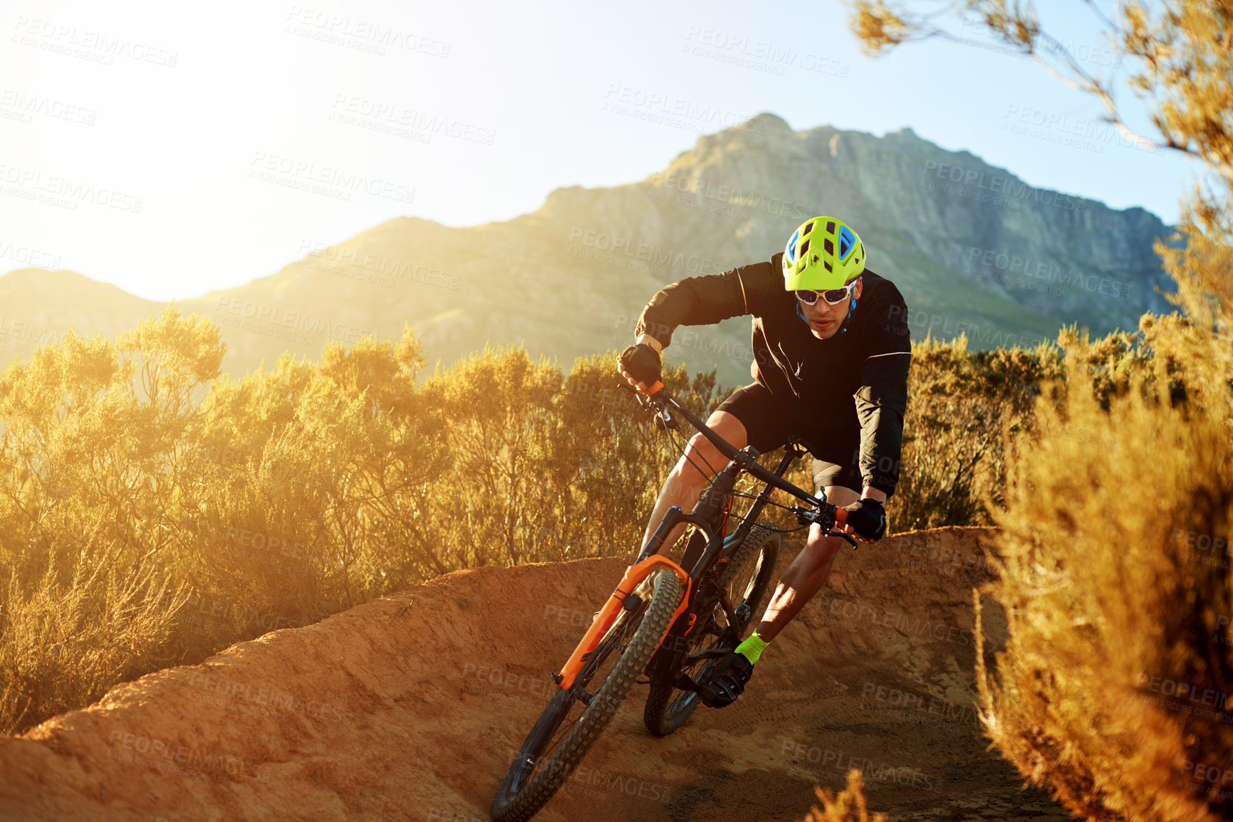 Buy stock photo Man, cyclist and mountain with sunset or bicycle on dirt track for adrenaline rush, fitness or extreme sport in nature. Male person, cycling or riding with bike for cardio on path, road or trail