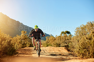 Buy stock photo Cycling, dirt road and helmet with man in mountains for outdoor exercise, fitness or trail. Bike, hobby and sunglasses with cyclist person in nature for challenge, performance or sports training