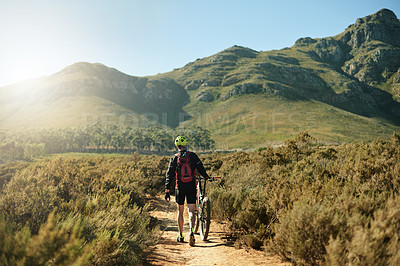 Buy stock photo Man, bicycle and athlete walking in nature, outdoor fitness and exercise break by mountain. Male person, back and travel to countryside for off road challenge, cardio rest and dirt practice on path