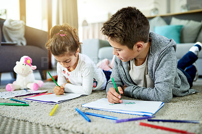 Buy stock photo Children, siblings and coloring homework in home, books and artistic activity for creative education. Kids, drawing together and bonding on floor of living room, support and learning lesson for fun