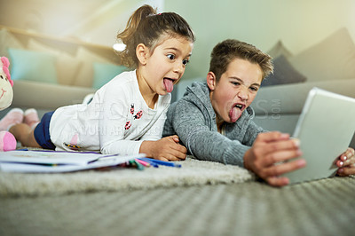Buy stock photo Children, crazy and relax in home with tablet, video call and online game on homework break. Kids, tongues out and technology in living room for cartoon comedy, face changing app and weekend bonding