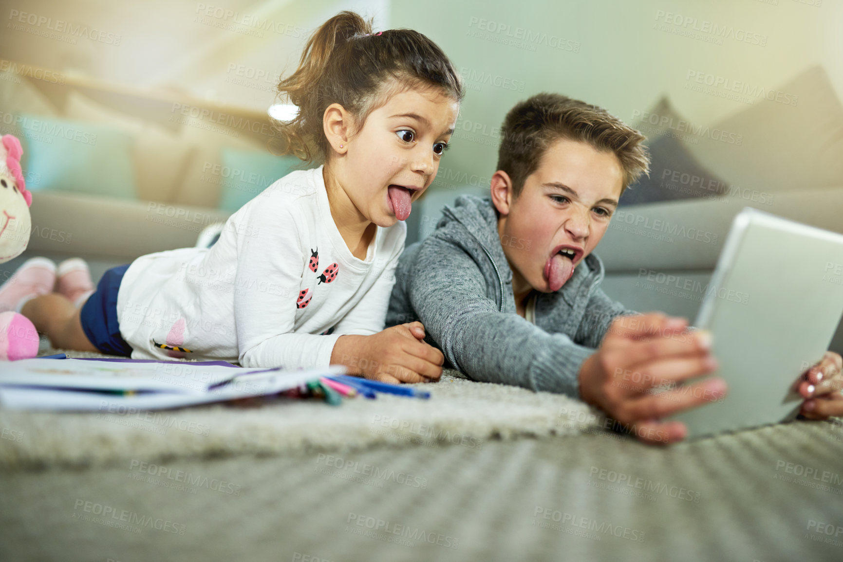 Buy stock photo Children, crazy and relax in home with tablet, video call and online game on homework break. Kids, tongues out and technology in living room for cartoon comedy, face changing app and weekend bonding