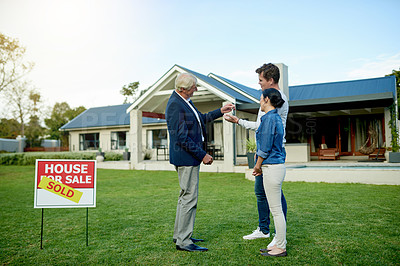 Buy stock photo Realtor, couple and new house sale with key for mortgage, loan or property investment outdoor. Man, woman and real estate agent giving keychain for moving, smile or purchase dream home for relocation