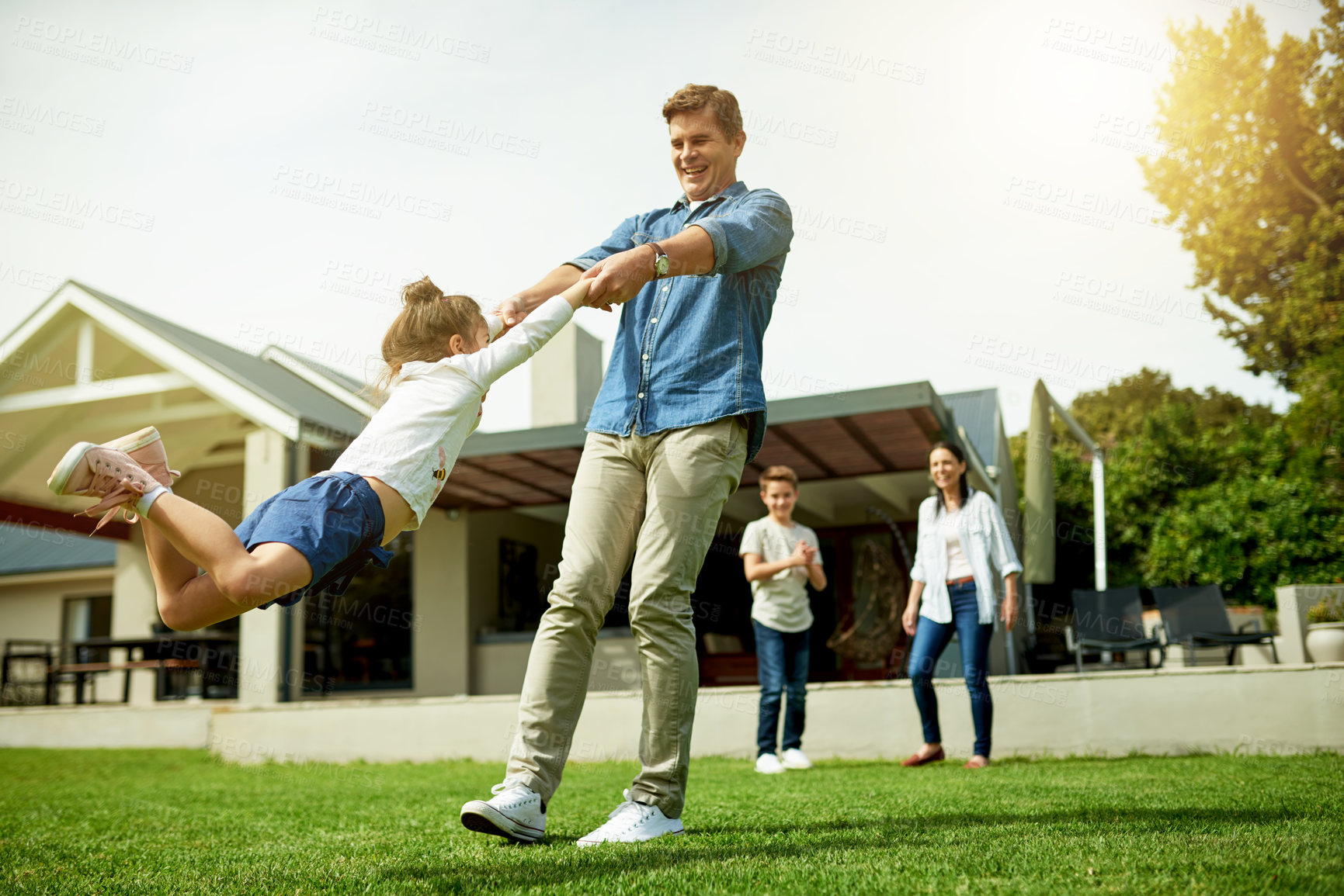 Buy stock photo Backyard, family and father swinging child in home garden for bonding, connection and fun together. Happy, love and dad spinning and playing with girl kid on weekend outdoor of house in summer.