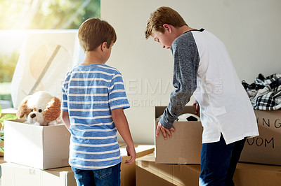 Buy stock photo Home, kids and packing toys in boxes, moving and helping relocation on living room floor. Brothers, real estate investment and together support in new house, dream property and leaving apartment