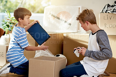 Buy stock photo Home, children and packing toys in boxes, moving and helping relocation on living room floor. Brothers, real estate investment and together support in new house, dream property and leaving apartment