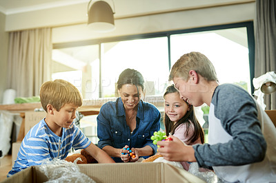 Buy stock photo Moving, boxes and family packing in new home with sorting items for donation, charity or community. Cardboard, fun and parents helping children sort household supplies for relocation in house.
