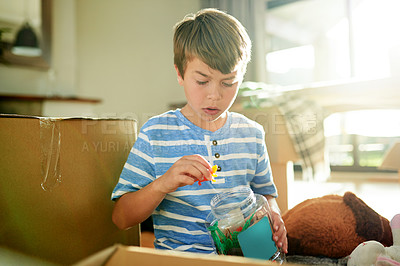 Buy stock photo Moving, kid and play with toys in new home, unboxing and unpacking for future relocation. Real estate mortgage, container and boy in house with storage jar for game, imagination and child development