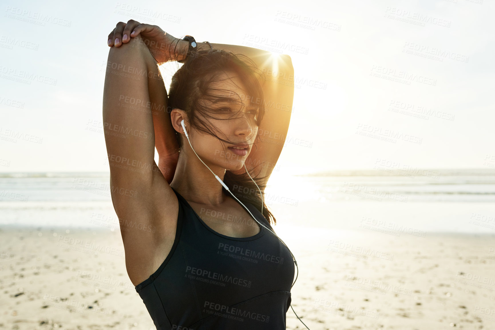 Buy stock photo Ocean, music and woman stretching for fitness, healthy body and wellness at sea. Warm up arms, earphones and athlete outdoor to prepare for exercise, training and ready for sports workout at beach