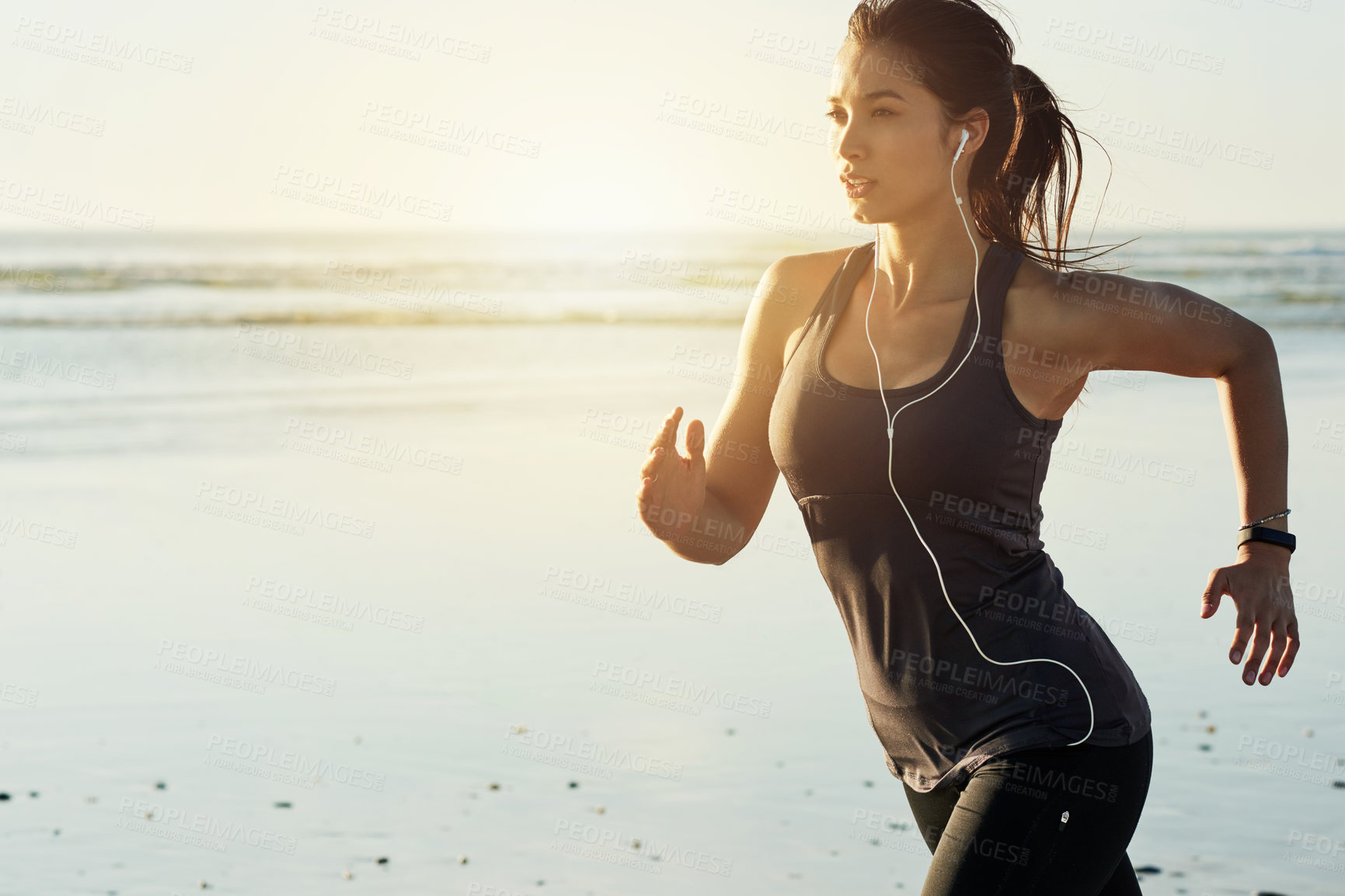 Buy stock photo Fitness, running and woman on beach with earphones, sunrise and commitment to healthy outdoor workout. Music, training and girl jogging at ocean for morning exercise, body wellness or space in nature
