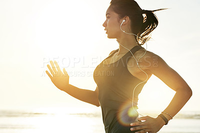 Buy stock photo Sunrise, running and woman on beach with earphones, fitness and commitment to healthy outdoor workout. Music, training and girl at ocean for morning exercise, body wellness and jogging in nature.