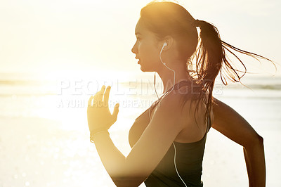 Buy stock photo Workout, running and woman on beach with earphones, sunrise and commitment to healthy outdoor fitness. Music, training and girl at ocean for morning exercise, body wellness and jogging in nature.