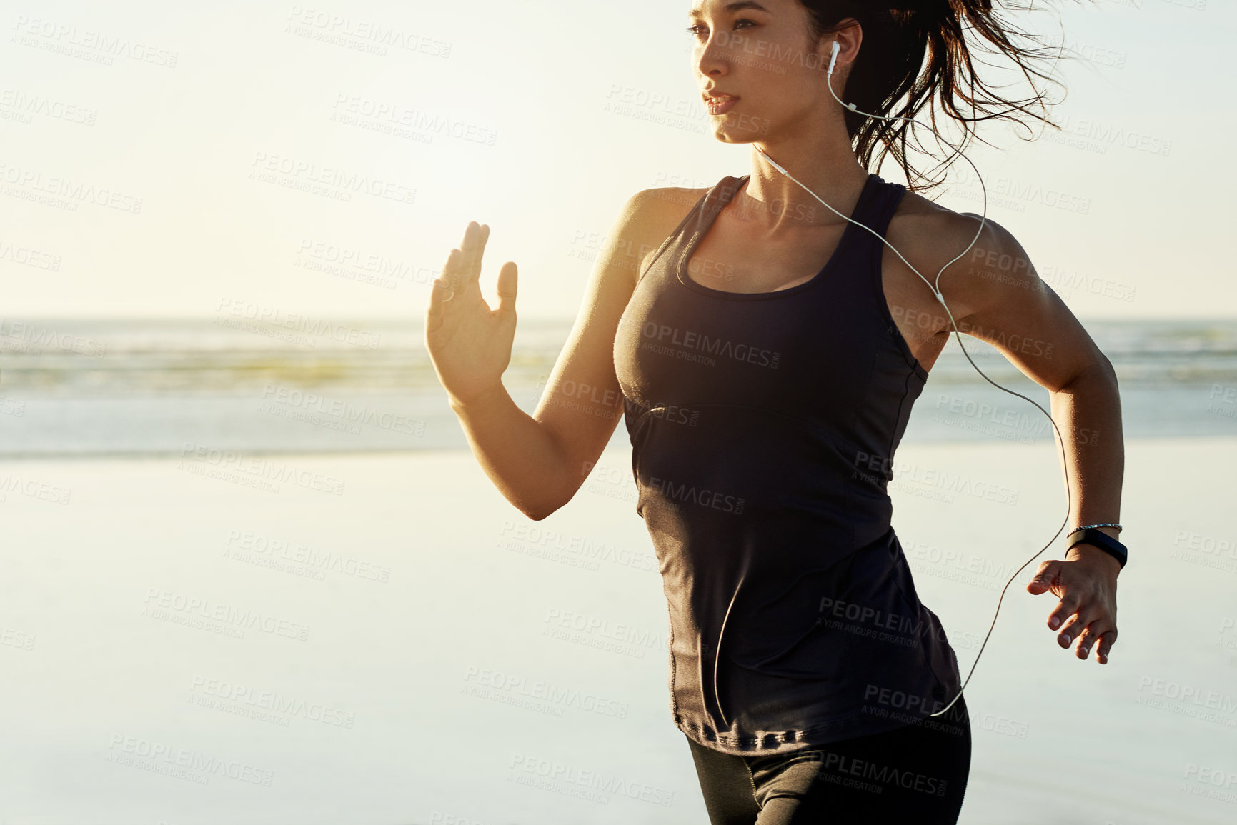 Buy stock photo Exercise, running and girl at ocean with earphones, sunrise and commitment to healthy outdoor workout. Music, training and woman at beach for morning fitness, body wellness and jogging in nature.