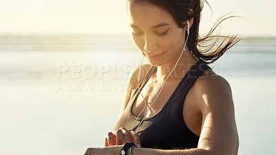 Buy stock photo Smart watch, fitness and woman at sea with music, check exercise progress or heart rate at sunset. Beach, wristwatch and sports athlete outdoor for steps, workout results and pulse for body health