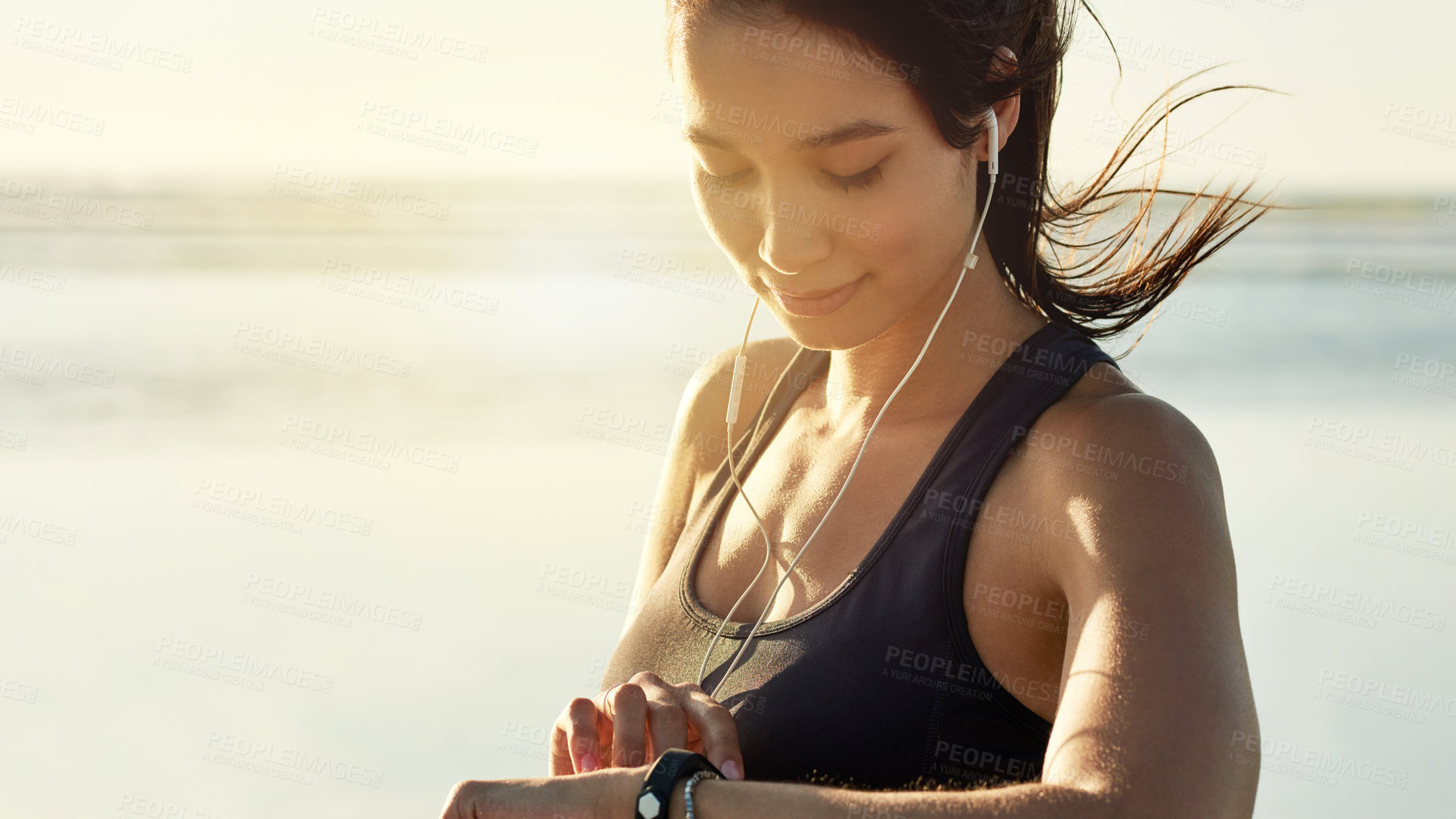 Buy stock photo Smart watch, fitness and woman at sea with music, check exercise progress or heart rate at sunset. Beach, wristwatch and sports athlete outdoor for steps, workout results and pulse for body health