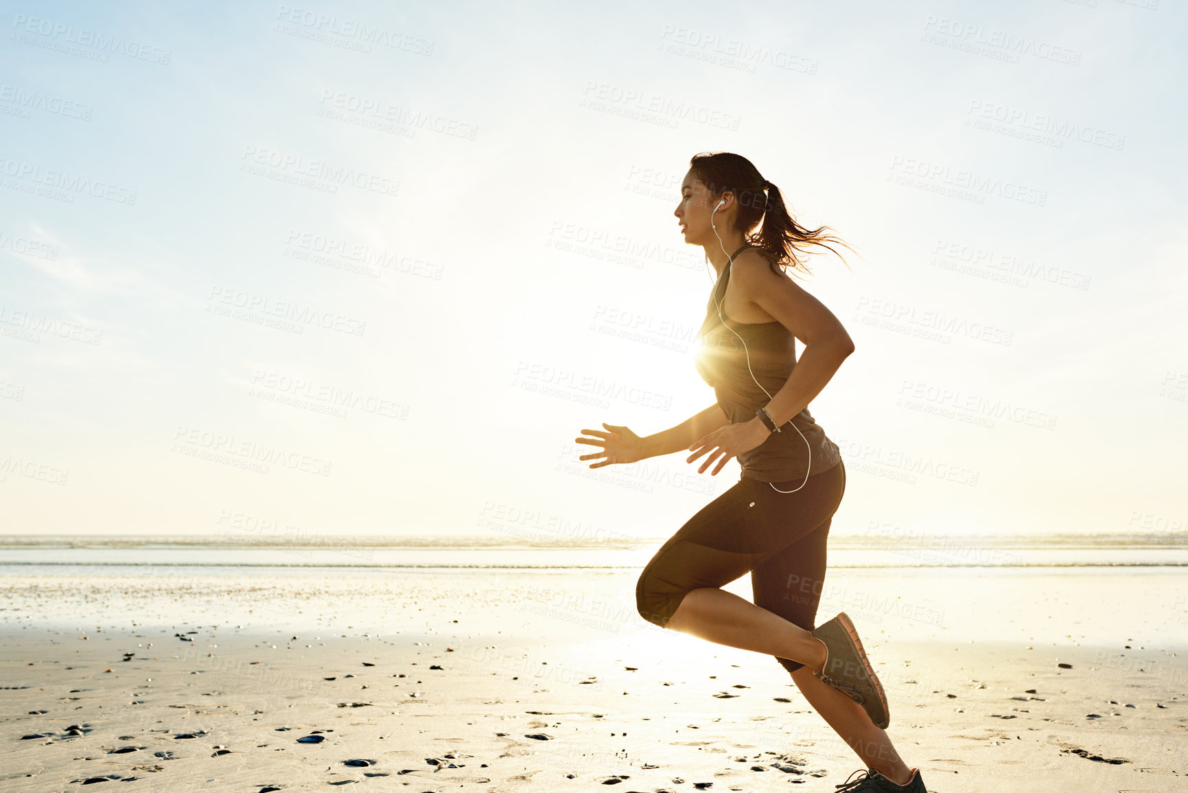 Buy stock photo Workout, running and girl on beach with earphones, sunrise and commitment to healthy outdoor exercise. Music, training and woman at ocean for morning fitness, body wellness and mockup space in nature