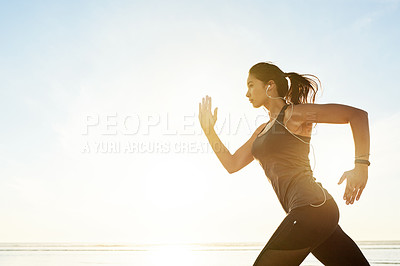 Buy stock photo Fitness, running and woman at ocean with music, sunrise and commitment to healthy outdoor workout. Earphones, training and girl runner at beach for morning exercise, body wellness and mockup space.