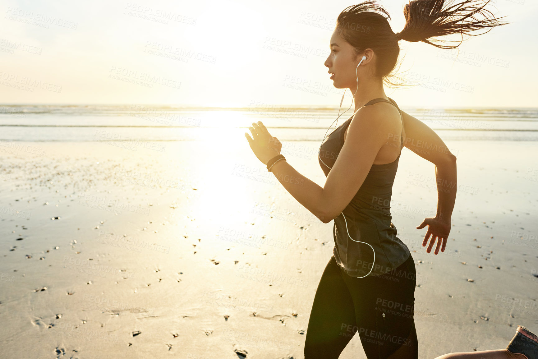 Buy stock photo Woman, beach and running at sunrise with earphones, training and listening to music with fitness in morning. Girl, person and sound with streaming, subscription and exercise with speed in Spain