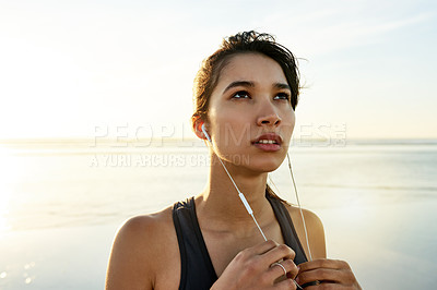 Buy stock photo Thinking, woman and earphones of fitness at ocean for exercise, listening to music and training recovery. Female athlete, tired and resting with streaming audio, marathon practice and workout burnout
