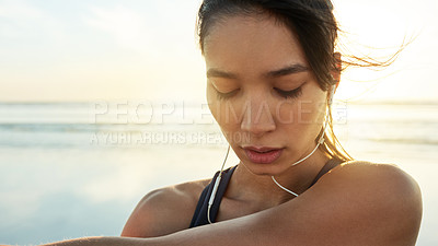 Buy stock photo Tired, woman and earphones for fitness at beach from exercise, listening to music and training recovery. Female athlete, fatigue and rest with streaming audio, marathon practice and wellness workout