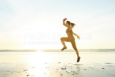 Buy stock photo Woman, running and jump for fitness at beach with energy, exercise and cardio training. Female athlete, air and runner with marathon performance for sports race, speed workout and competition goals