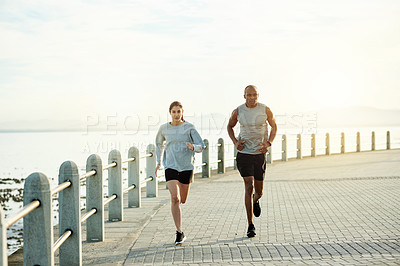 Buy stock photo Promenade, couple and sports with running for fitness, cardiovascular health and wellness with exercise. Outdoor, man and woman with training for marathon challenge, endurance and energy by beach
