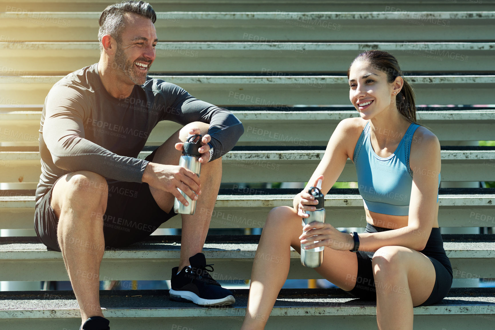 Buy stock photo Talking, fitness and couple on break, steps and happy for exercise in morning, summer and healthy. Outdoor, rest and people with sportswear for workout, training and smile with routine for wellness