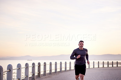 Buy stock photo Beach, running and man with fitness, cardio and wellness with workout, promenade and practice. Person, athlete and runner with performance, exercise and sports with body health, challenge and energy