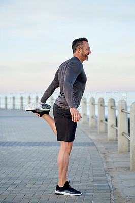 Buy stock photo Mature man, stretching and legs on promenade by ocean with warm up for exercise, health and fitness in morning. Person, outdoor and start routine for running, training and profile by sea in Italy