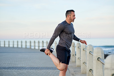 Buy stock photo Mature man, exercise and stretching, promenade and ocean with warm up for legs, health and fitness in morning. Person, outdoor and start routine for running, training and profile by sea in Italy