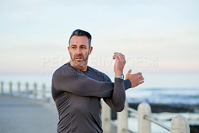 Buy stock photo Fitness, mature man and stretching by beach for workout preparation, getting ready and muscle recovery. Space, arms warm up and training at promenade for wellness challenge and exercise performance