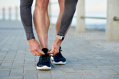 Buy stock photo Man, athlete and tie shoelace by ocean, sports preparation and outdoor for marathon training. Male person, sneakers and getting ready for cardio challenge on sea promenade, runner and start workout
