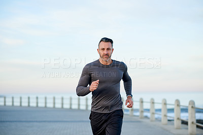 Buy stock photo Beach, running and man with sports, practice and wellness with fitness, energy and routine. Ocean, athlete and runner with workout, exercise and cardio with body health, challenge and endurance