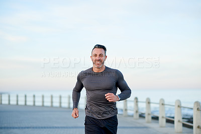 Buy stock photo Mature man, happy and running on promenade, excited and portrait for fitness, health and ocean in morning. Person, exercise and smile by sea, wellness and workout with mock up space in Australia