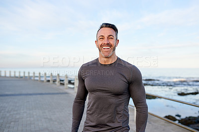 Buy stock photo Mature man, runner and smile on promenade by ocean, break or pride with portrait for workout in morning. Person, training and fitness by sea with confidence, happy or outdoor for exercise in Spain