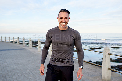Buy stock photo Mature man, fitness and happy on promenade by ocean, break or pride with portrait for workout in morning. Person, training and runner by sea with confidence, smile or outdoor for exercise in Spain