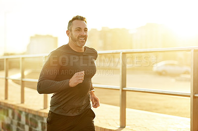 Buy stock photo Man, happy or running in city for fitness, cardio exercise or training for marathon with lens flare. Mature athlete, sunset or smile in Portugal for workout routine, physical care or wellness journey