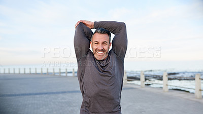 Buy stock photo Happy, mature man and stretching by beach to start, getting ready and muscle preparation outdoor. Athlete, arms warm up and smile at promenade for cardio, wellness challenge and exercise performance